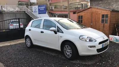 a white car parked in front of a building at Casa da Maria in Prazeres
