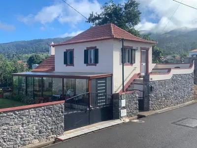 a house with a stone wall and a balcony at Casa da Maria in Prazeres