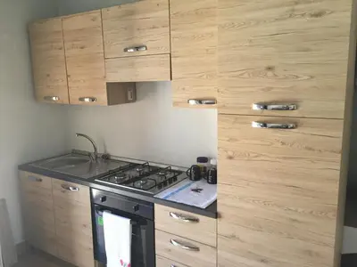 a kitchen with a stove and wooden cabinets at Casa da Maria in Prazeres