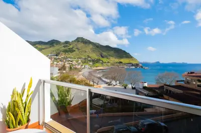 a balcony with a view of a beach and the ocean at Residencial Familia in Machico