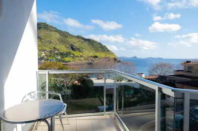 a balcony with a table and a view of the ocean at Residencial Familia in Machico