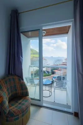 a living room with a sliding glass door to a balcony at Residencial Familia in Machico
