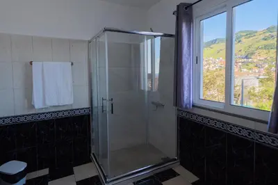a shower stall in a bathroom with a window at Residencial Familia in Machico