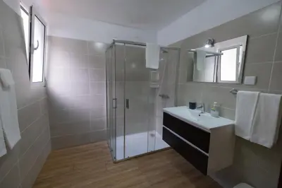 a bathroom with a glass shower and a sink at Residencial Familia in Machico