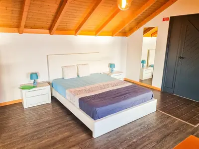 a bedroom with a large bed and two night stands at Studio One | Massapez | Fajã da Ovelha | Calheta in Fajã da Ovelha