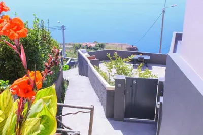 a balcony with orange flowers and a view of the ocean at Studio Two | Massapez | Fajã da Ovelha | Calheta in Fajã da Ovelha