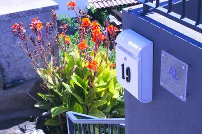 a blue mailbox next to a garden with flowers at Studio Two | Massapez | Fajã da Ovelha | Calheta in Fajã da Ovelha