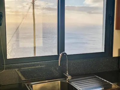 a kitchen sink and a window with a view of the ocean at Studio Two | Massapez | Fajã da Ovelha | Calheta in Fajã da Ovelha