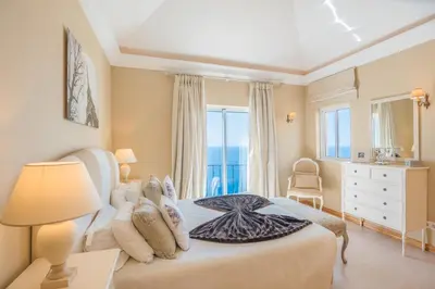 a bedroom with a bed and a large window at Luxury One Bedroom Palheiro Village by Holiday Rental Madeira in Funchal