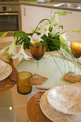 a table with plates and glasses on a table with flowers at Luxury One Bedroom Palheiro Village by Holiday Rental Madeira in Funchal