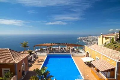 a swimming pool with a view of the ocean at Luxury One Bedroom Palheiro Village by Holiday Rental Madeira in Funchal