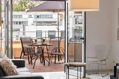 a patio with a table and chairs on a balcony at Arriaga I by An Island Apart in Funchal