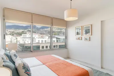 a bedroom with a large window with a view at Arriaga I by An Island Apart in Funchal