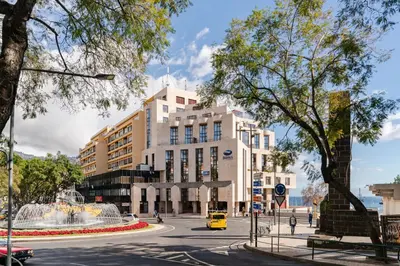 a building with a fountain in the middle of a street at Arriaga I by An Island Apart in Funchal