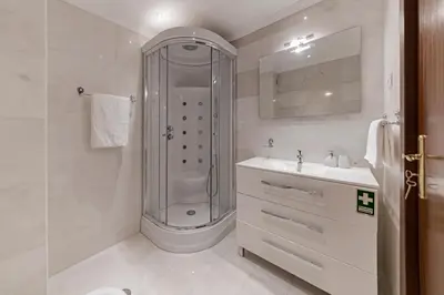 a white bathroom with a shower and a sink at Arriaga I by An Island Apart in Funchal