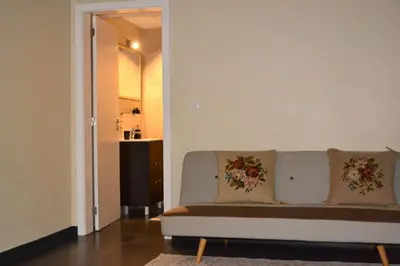 a living room with a white couch with two pillows at Casa do Lado in Ponta do Sol
