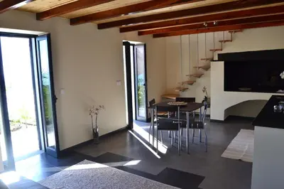 a living room with a table and chairs and a staircase at Casa do Lado in Ponta do Sol