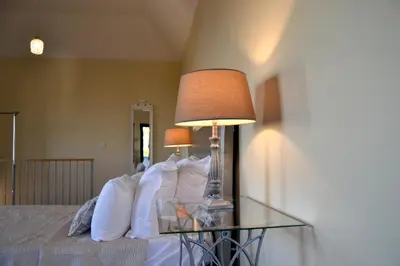 a bedroom with a bed with a table with a lamp at Casa do Lado in Ponta do Sol