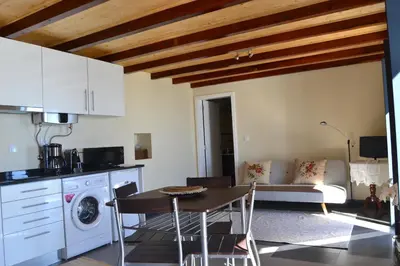 a kitchen and living room with a table and a couch at Casa do Lado in Ponta do Sol