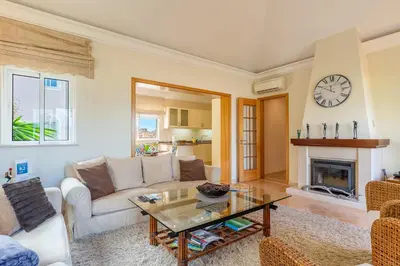 a living room with a couch and a fireplace at Luxury two bedroom Palheiro Village by Holiday Rental Madeira in Funchal