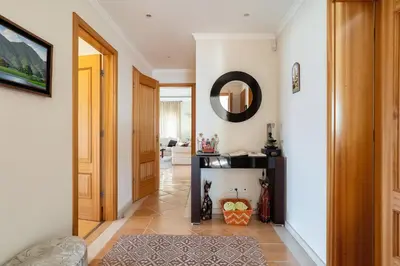 a hallway with a door and a mirror on the wall at Luxury two bedroom Palheiro Village by Holiday Rental Madeira in Funchal