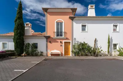 a large white house with a yellow door at Luxury two bedroom Palheiro Village by Holiday Rental Madeira in Funchal