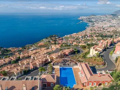 an aerial view of a village with houses and the ocean at Luxury two bedroom Palheiro Village by Holiday Rental Madeira in Funchal