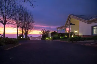 a house on a street with a sunset in the background at Luxury two bedroom Palheiro Village by Holiday Rental Madeira in Funchal