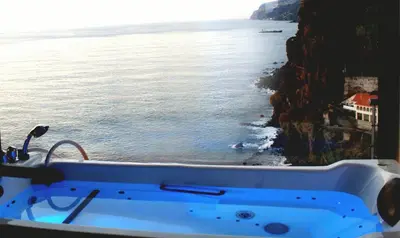 a bath tub with a view of the ocean at Estalagem Da Ponta Do Sol in Ponta do Sol
