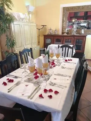 a table with a white table cloth and red roses on it at Inn & Art Madeira in Caniço