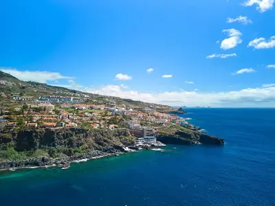 an aerial view of a town on a hill next to the ocean at Inn & Art Madeira in Caniço