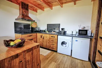 a kitchen with a washing machine and a dishwasher at Chale Jardim De Cima in São Vicente