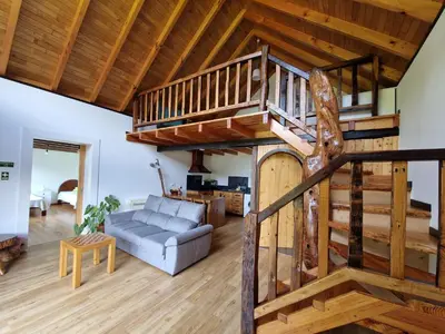 a large living room with a wooden spiral staircase at Chale Jardim De Cima in São Vicente