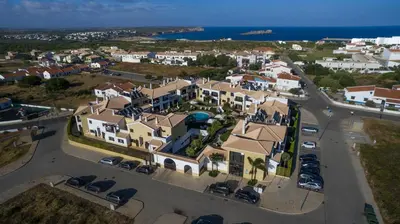 a bedroom with a large bed and a mirror at Sagres Time Apartamentos in Sagres