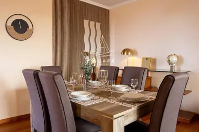 a dining room with a wooden table and chairs at Vila Sol in Prazeres