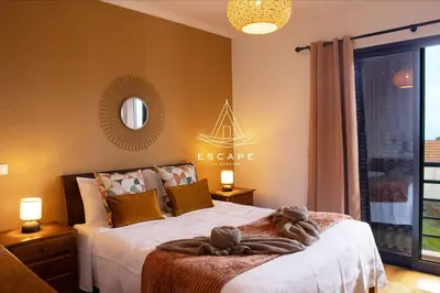 a bedroom with a bed and a large window at Vila Sol in Prazeres