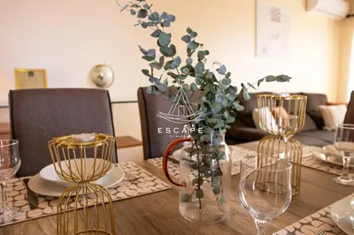 a table with glasses and a vase with flowers in it at Vila Sol in Prazeres