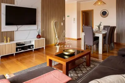 a living room with a couch and a table with a television at Vila Sol in Prazeres