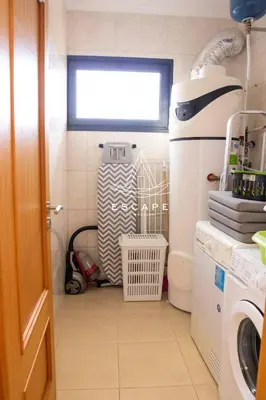 a small bathroom with a washing machine and a window at Vila Sol in Prazeres
