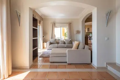 a living room with a couch and a table at Designed Villa Palheiro Village by Holiday Rental Madeira in Funchal