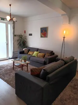 a living room with a blue couch and a table at Casa da Fonte dos Castanheiros in Estreito da Calheta