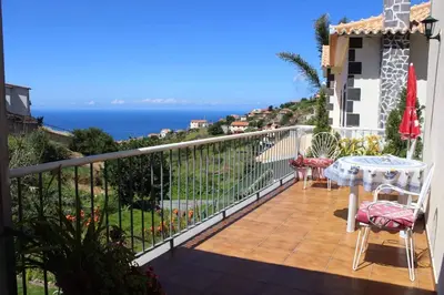 a balcony with a table and a view of the ocean at Casa da Fonte dos Castanheiros in Estreito da Calheta