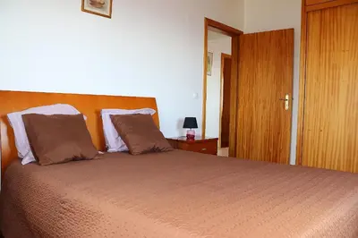 a bedroom with a large bed with a wooden headboard at Casa Bela Vista in Ribeira Brava