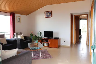 a living room with a couch and a tv at Casa Bela Vista in Ribeira Brava