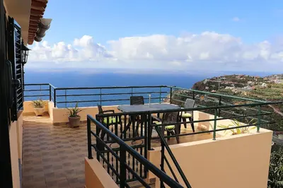 a balcony with a table and a view of the ocean at Casa Bela Vista in Ribeira Brava