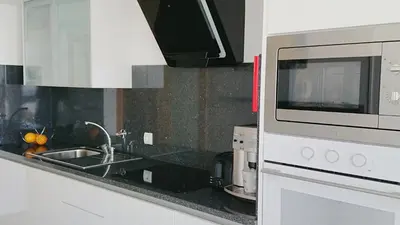 a kitchen with a sink and a microwave at Apartamento Doreen in Caniço