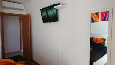 a room with a door with a television on the wall at Apartamento Doreen in Caniço