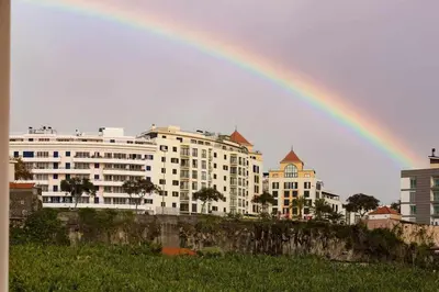 a rainbow in front of a large building at Elena's Apartment - Nice sea views in Panasqueira