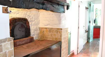 a stone fireplace in a room with a doorway at OurMadeira - Cottage do Mar in Arco da Calheta