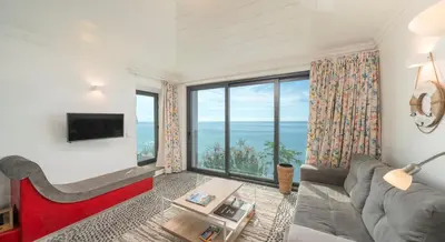 a living room with a couch and a large window at OurMadeira - Cottage do Mar in Arco da Calheta